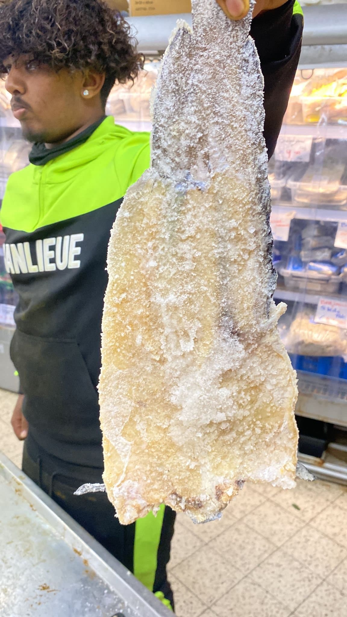 Mitarbeiter im Laden mit einem ganzen gesalzenen Bakkeljauw